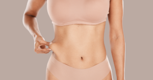 a woman's body showing her hip fat by gripping it with her right hand
